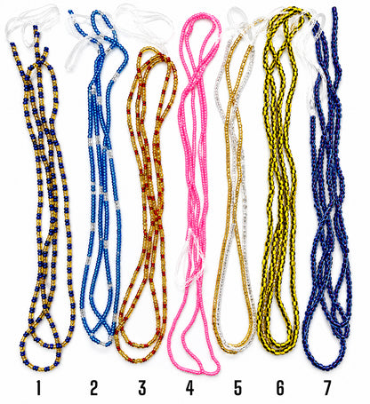 Seven strands of seed bead necklaces or cords shown vertically on a white background, numbered 1 through 7. The colors are blue and yellow, brown and gold, pink, silver and gold, yellow and gold, and dark blue.