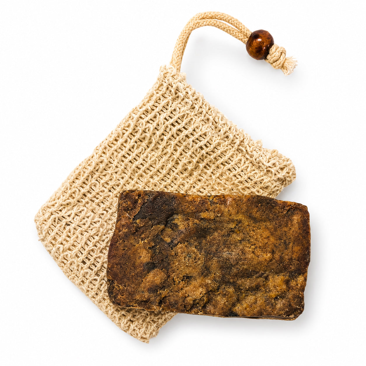 A dark brown textured soap bar resting on a small woven natural-fiber pouch with a drawstring and wooden bead, photographed on a clean white background.