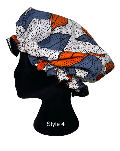 A bonnet with a colorful abstract leaf pattern in navy blue, orange, and white with black dots, displayed on a black mannequin head. The text 'Style 4' is printed on the mannequin stand.