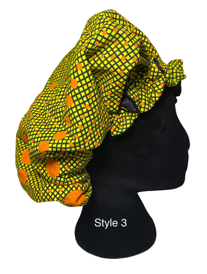 A black mannequin head wearing a bright yellow and green patterned fabric bonnet with orange circular motifs, shown against a plain white background with the text 'Style 3' on the mannequin.