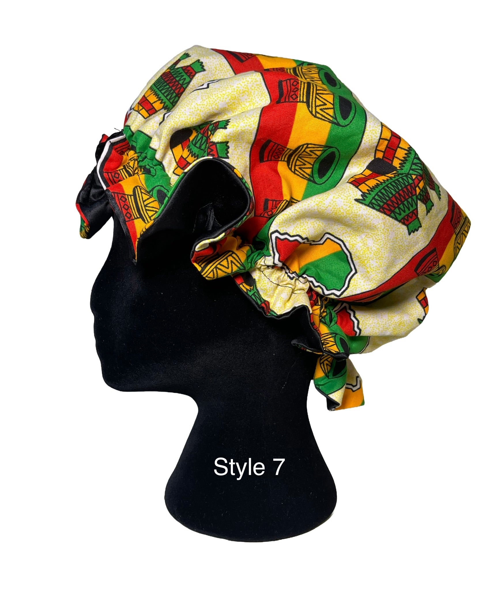 A fabric bonnet with a vibrant African-inspired pattern in red, yellow, green, and cream, displayed on a black mannequin head. The text 'Style 7' is printed on the mannequin neck.