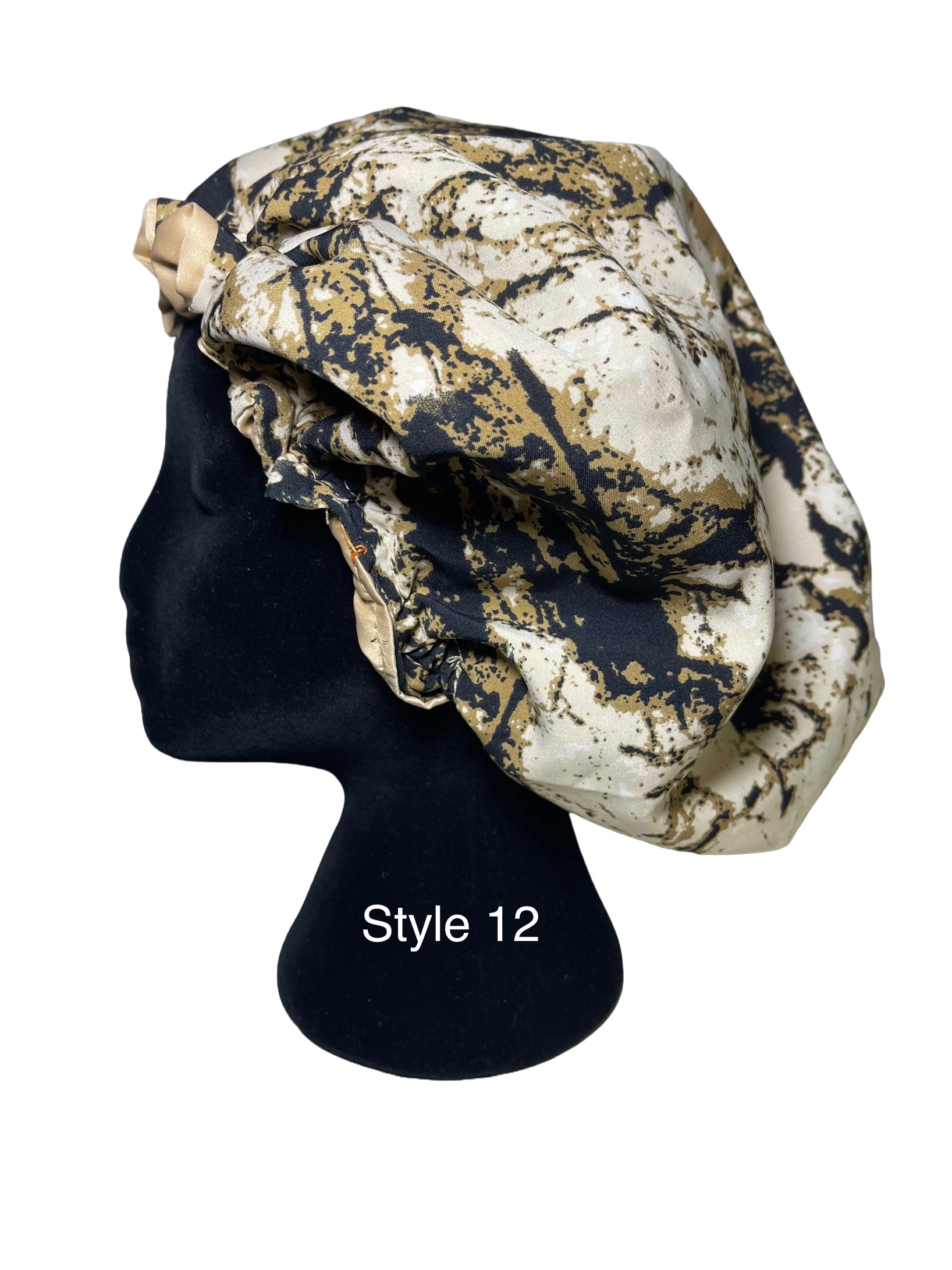 A patterned bonnet draped on a black mannequin head, featuring an abstract marbled design in beige, gold, and dark navy blue. The text 'Style 12' is printed in white on the mannequin stand.