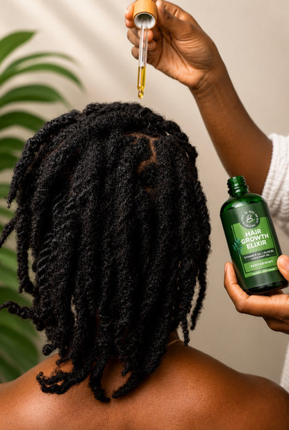 A person shown from the back with long black dreadlocks, while another hand holds a dropper above the hair and a green bottle labeled Hair Growth Serum is visible in the other hand. A soft beige wall and green plant leaves appear in the background.